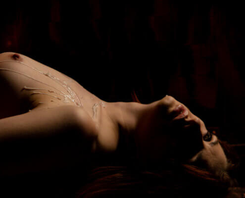 Hot wax drips on a woman's bare chest; MarriageHeat