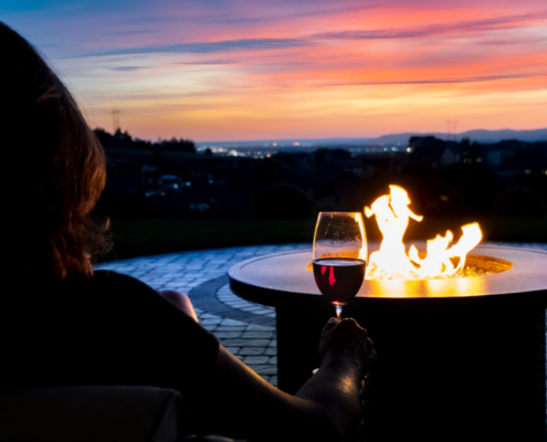 Enjoying a glass of wine at the outdoor fire table ~ MarriageHeat.