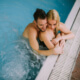 Husband and wife cuddle poolside ~ MarriageHeat
