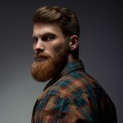 Mitzy's dream husband, a bearded man in a flanel shirt gives a piercing look over his shoulder ~ MarriageHeat