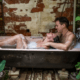 Man bathing his wife in a romantic setting ~ MarriageHeat
