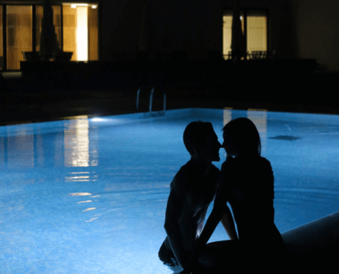 Husband and wife enjoying the pool after dark ~ MarriageHeat