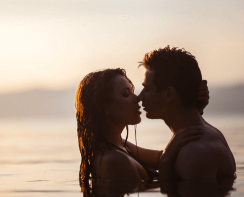 Husband and wife kissing in a placid lagoon ~ MarriageHeat