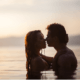 Husband and wife kissing in a placid lagoon ~ MarriageHeat