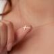 Woman balancing her cross necklace on her thumb - MarriageHeat