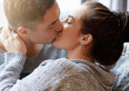 Huband and wife kiss passionately on the couch ~ MarriageHeat