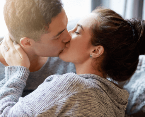 Huband and wife kiss passionately on the couch ~ MarriageHeat
