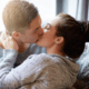 Huband and wife kiss passionately on the couch ~ MarriageHeat