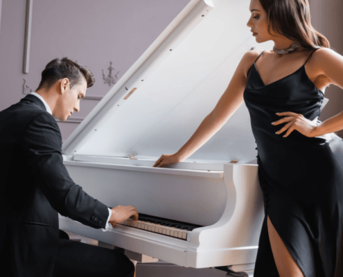 Husband plays the piano while his sexy wife looks on ~ MarriageHeat